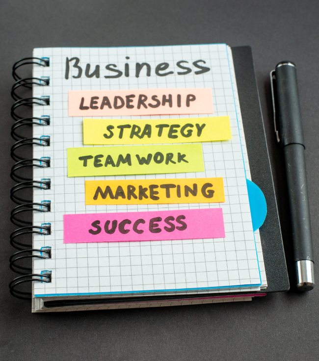 Notebook with the words Business, leadership, strategy, teamwork, marketing, and success.